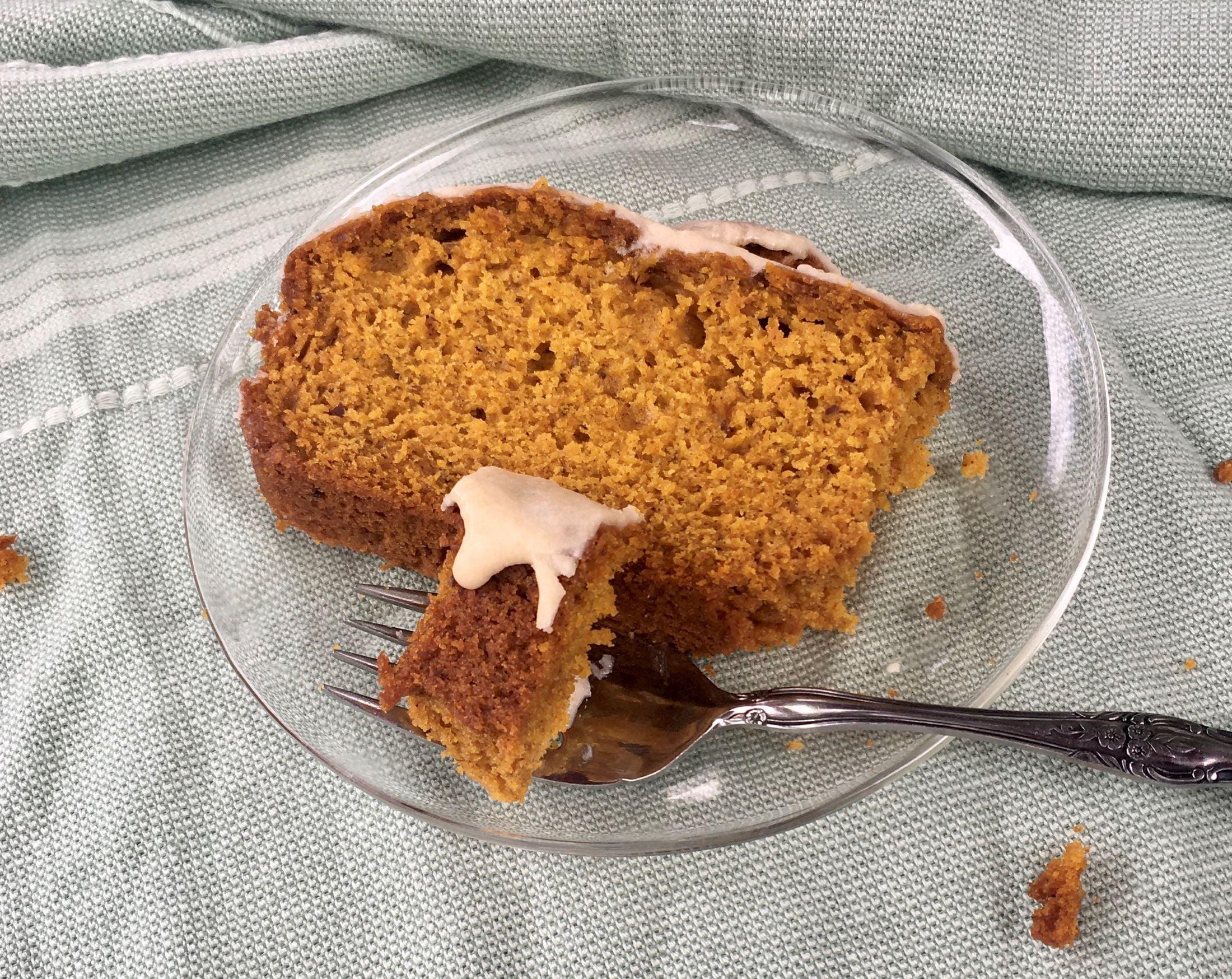 Slice of vegan pumpkin loaf with maple glaze.