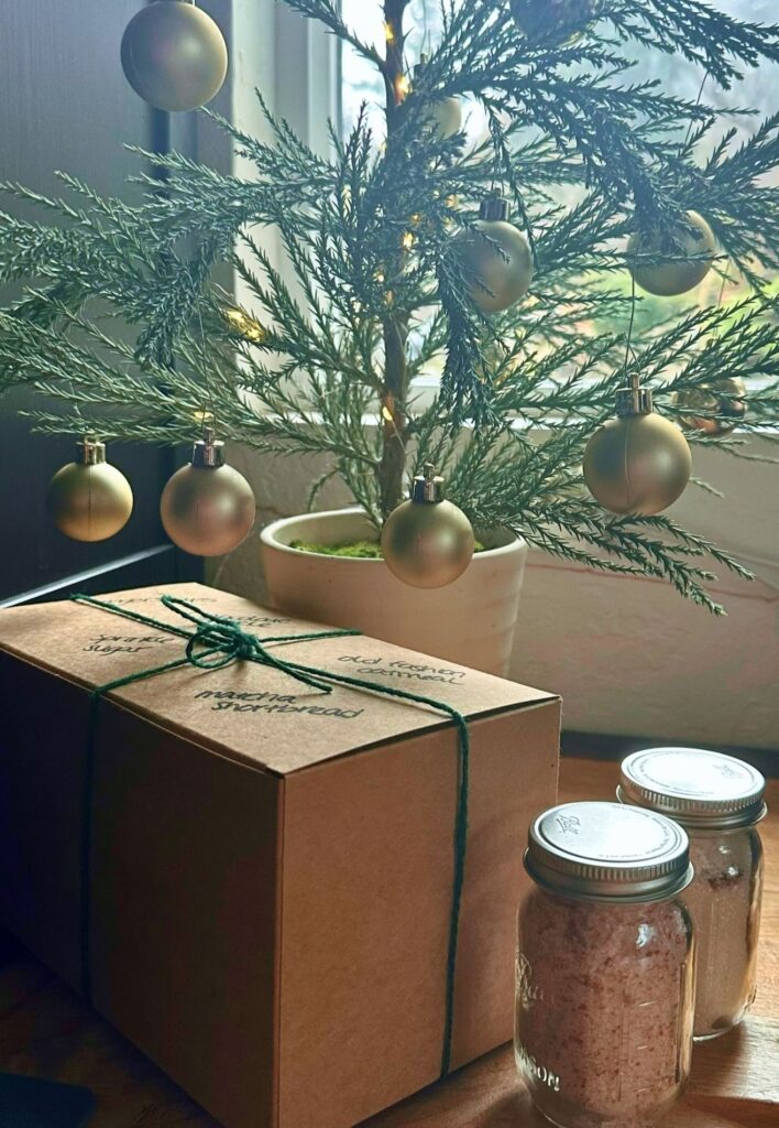 Packaged homemade gift ideas under mini Christmas tree.