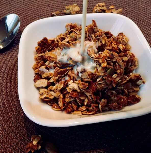 Vegan protein granola with soy milk being poured in.