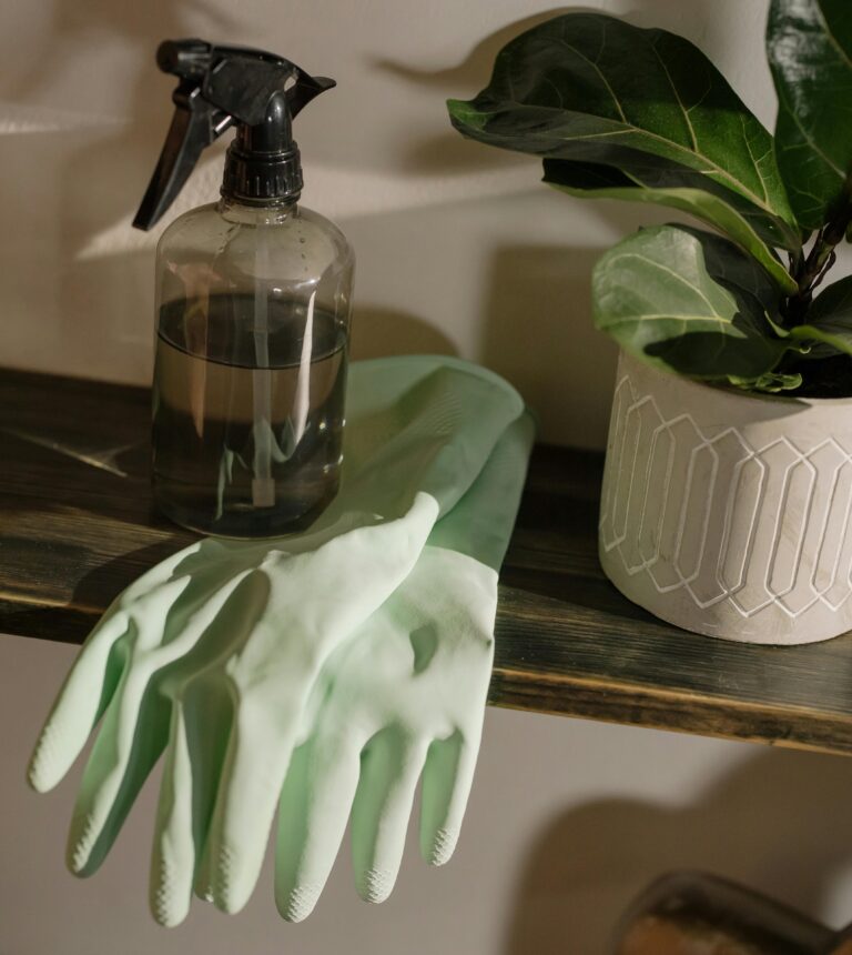 Sustainable spring cleaning with reusable gloves and refillable spray bottle.