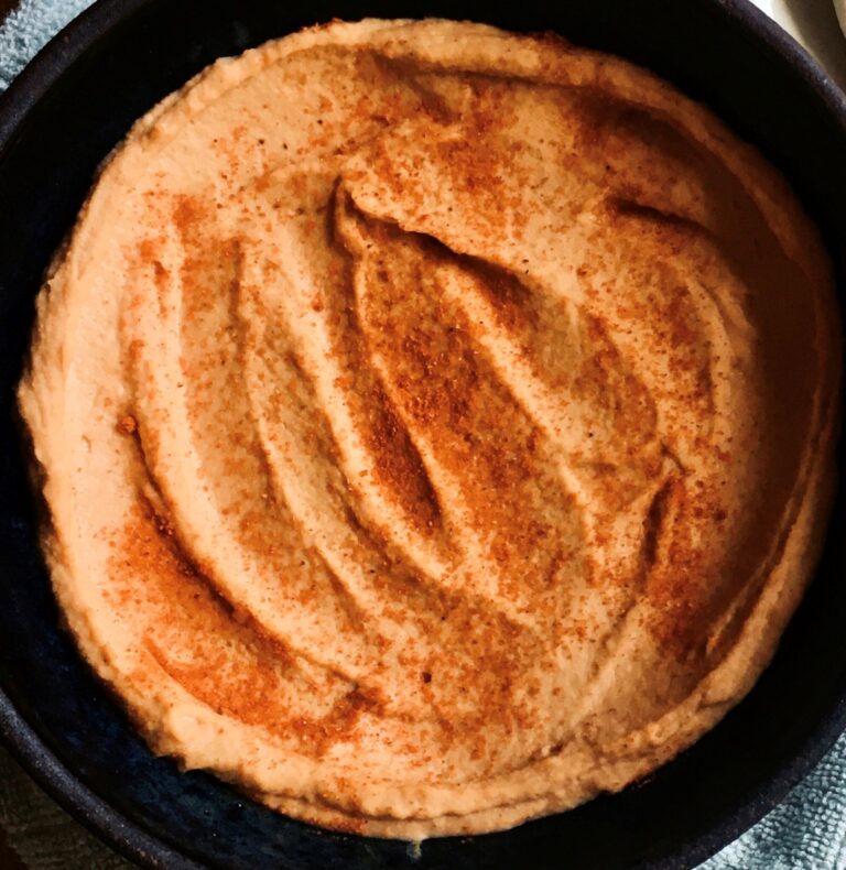 creamy buffalo hummus dip topped with cayenne.